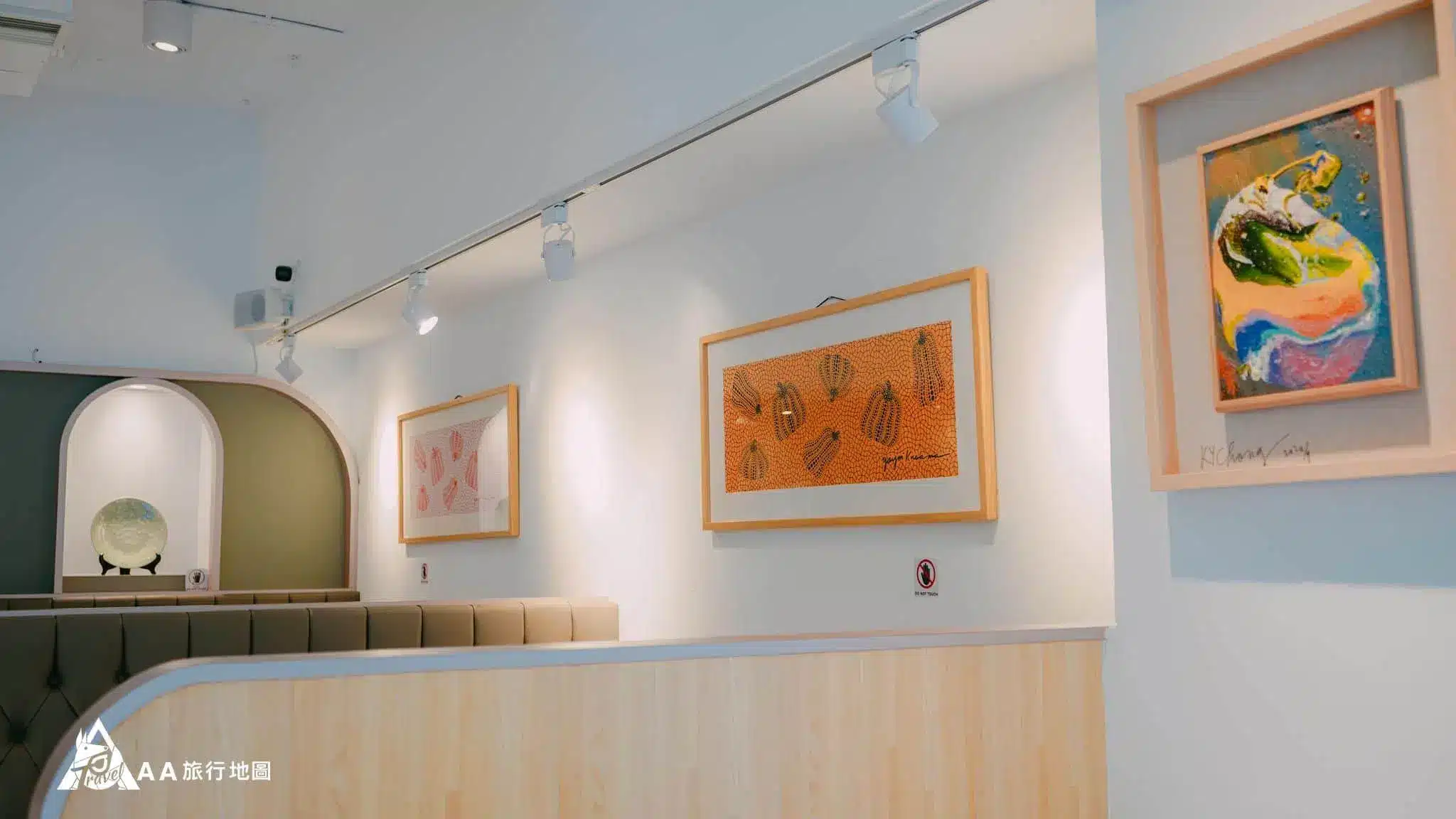 There are beautiful paintings hanging on the wall of pot bean flowers