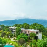 Looking at the Villa from a high altitude, it is very beautiful with the sky and mountains behind it.